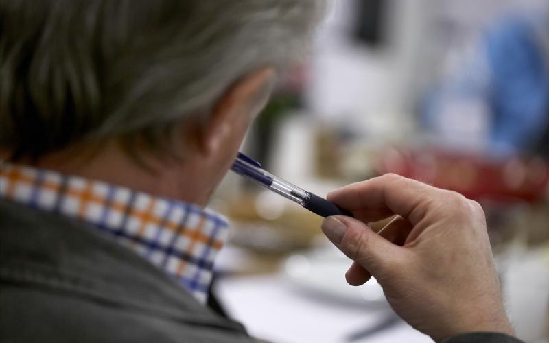 Mand fotograferet over skulderen siddende til et møde 