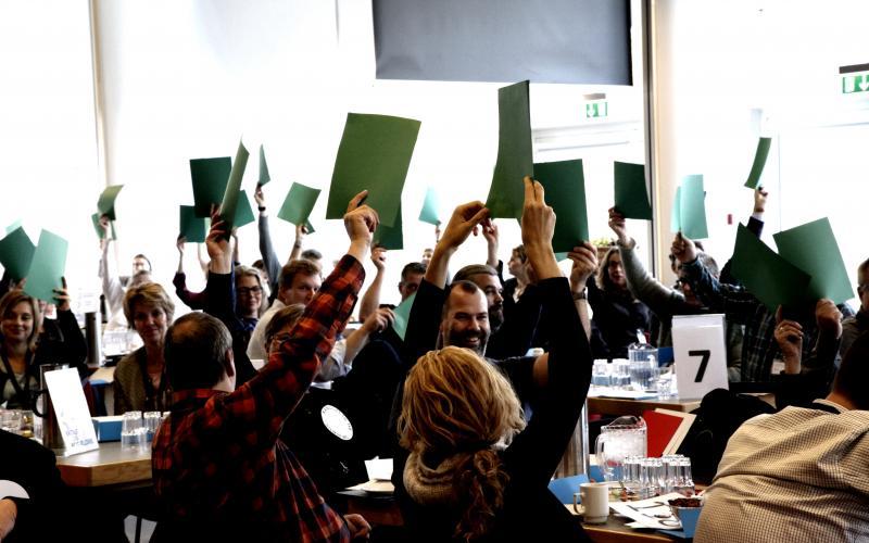 Folk til møde der holder papir op for at stemme