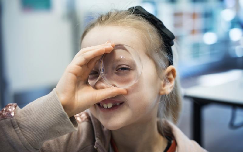 Piger kigger gennem glas