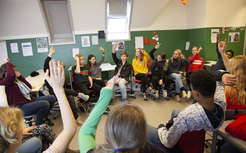 Elever rækker hånden op i klasselokale
