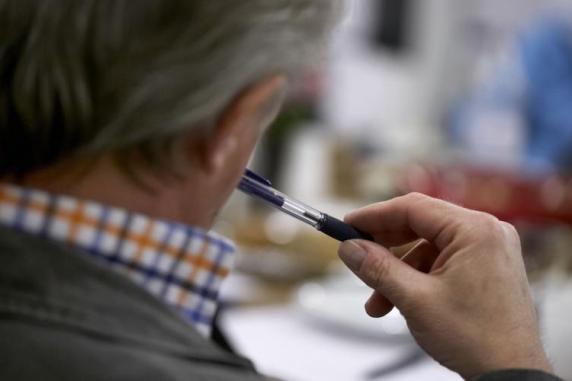 Mand fotograferet over skulderen siddende til et møde 